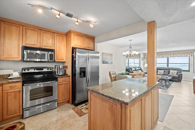 kitchen featuring light tile flooring, a textured ceiling, appliances with stainless steel finishes, dark stone countertops, and an inviting chandelier