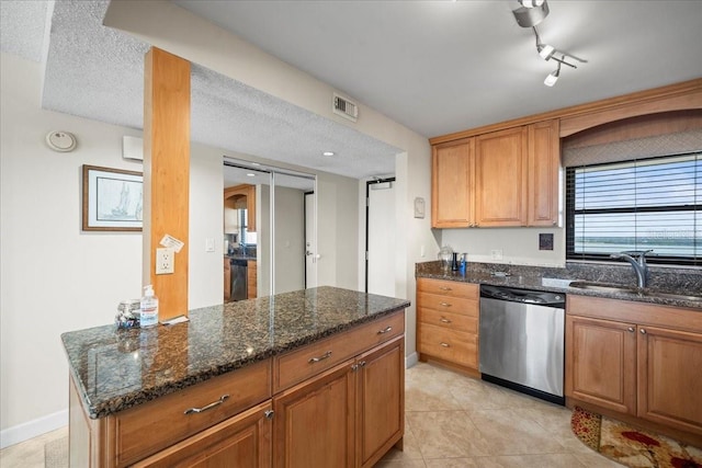 kitchen featuring light tile flooring, sink, a textured ceiling, rail lighting, and dishwasher