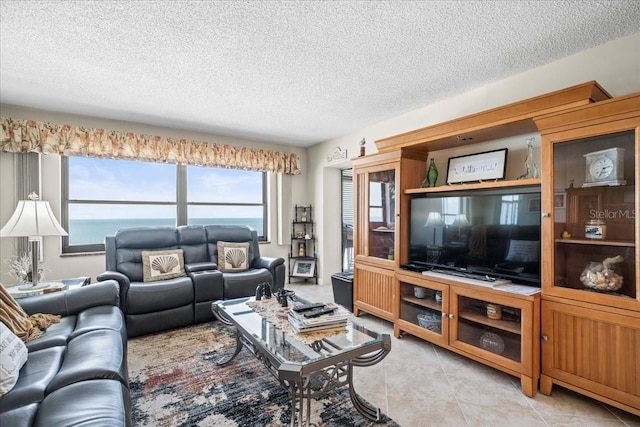 tiled living room with a textured ceiling and a water view