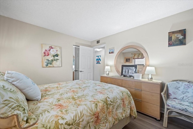 bedroom with dark wood-type flooring and a textured ceiling