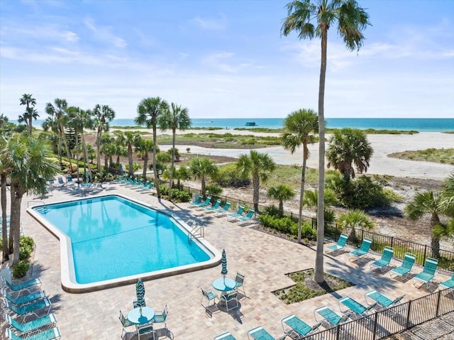 view of swimming pool featuring a patio and a water view