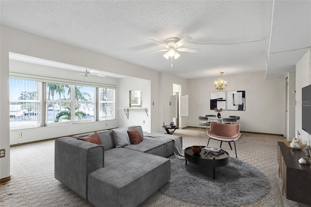 carpeted living room featuring a textured ceiling and ceiling fan with notable chandelier