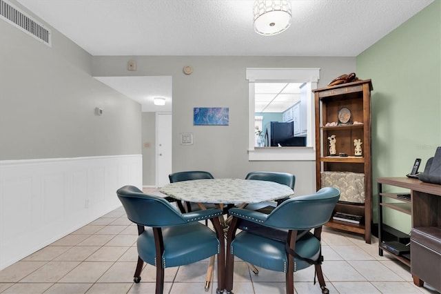 dining room with a textured ceiling and light tile flooring