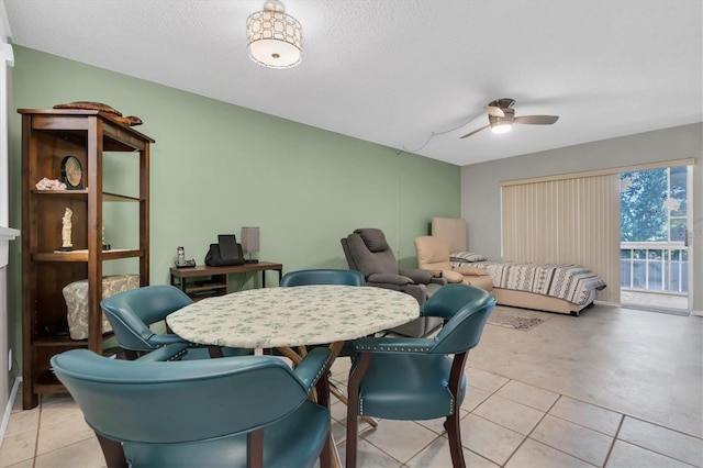 dining room with light tile floors, ceiling fan, and a textured ceiling