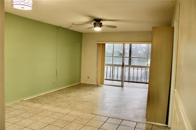 unfurnished room with ceiling fan and a textured ceiling