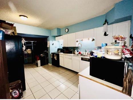 kitchen featuring electric stove, white cabinets, light tile floors, and dishwasher