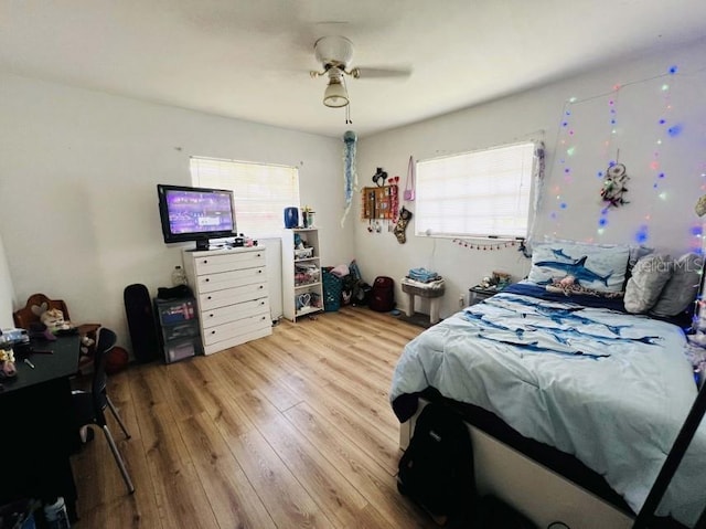 bedroom with light hardwood / wood-style floors, ceiling fan, and multiple windows