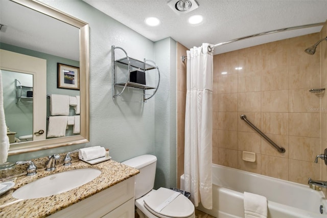 full bathroom with large vanity, shower / tub combo with curtain, toilet, and a textured ceiling