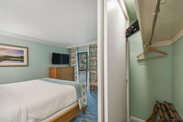 carpeted bedroom with a textured ceiling and crown molding