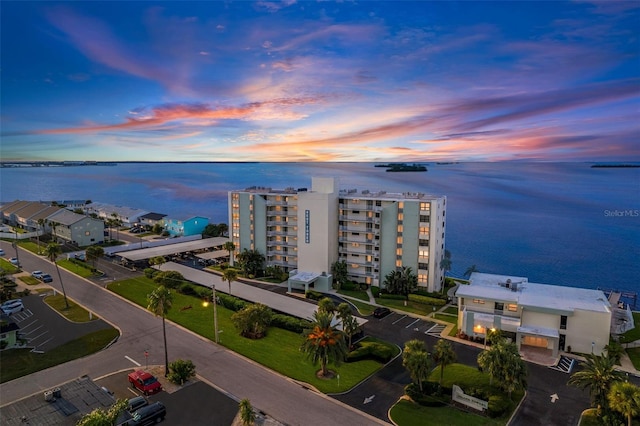 aerial view at dusk featuring a water view