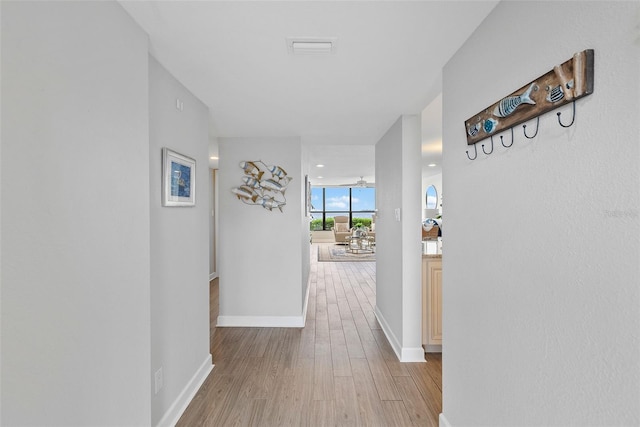 corridor with light hardwood / wood-style floors