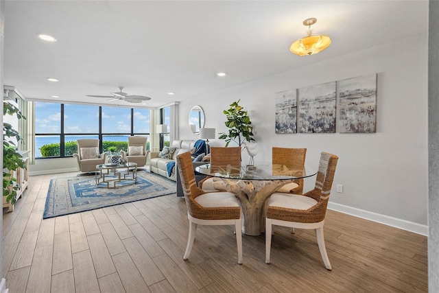 dining area featuring a water view, ceiling fan, and light wood-type flooring