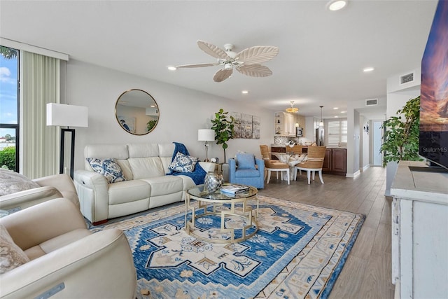 living room with plenty of natural light, ceiling fan, and light hardwood / wood-style flooring