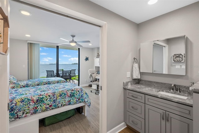 bedroom with ceiling fan, sink, access to outside, a water view, and light wood-type flooring