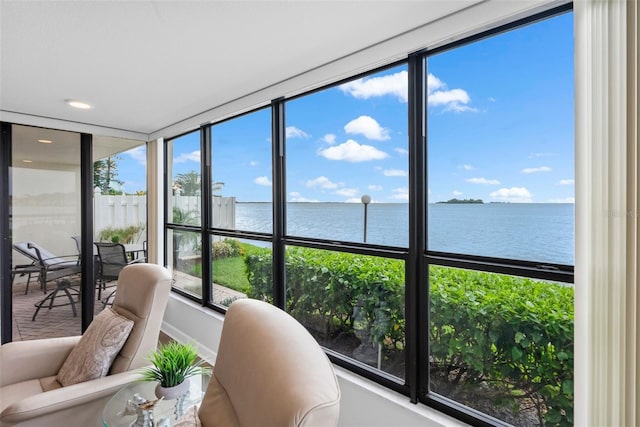 sunroom featuring plenty of natural light and a water view