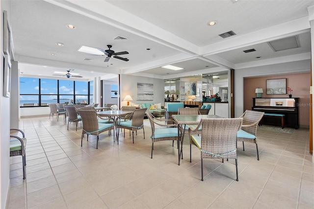 dining room featuring floor to ceiling windows, ceiling fan, light tile floors, and beamed ceiling