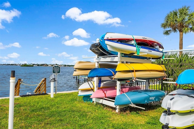 dock area with a lawn and a water view