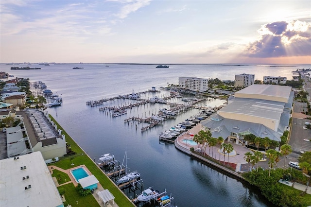 aerial view at dusk featuring a water view