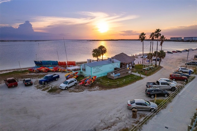 aerial view at dusk featuring a water view