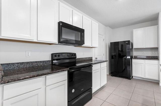 kitchen with dark stone counters, light tile floors, black appliances, and white cabinetry