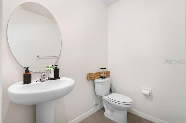 bathroom featuring toilet and tile floors