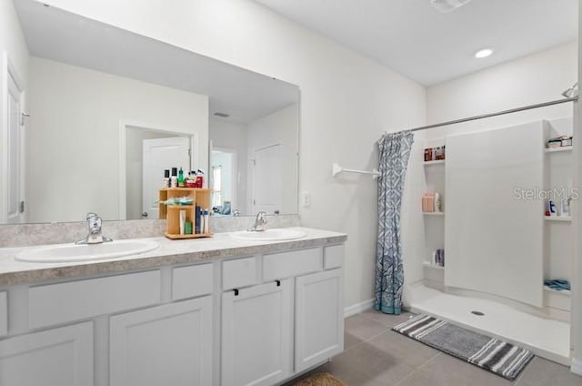 bathroom with curtained shower, tile floors, and dual vanity