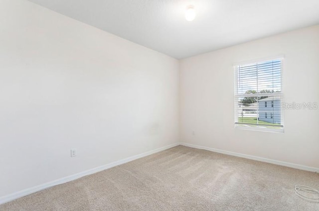 unfurnished room featuring light carpet