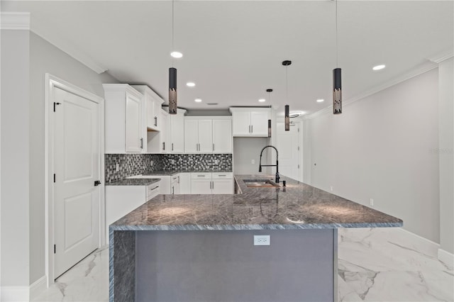 kitchen with white cabinets, sink, light tile flooring, a spacious island, and hanging light fixtures