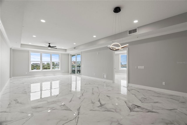 unfurnished room with ceiling fan with notable chandelier, a raised ceiling, and light tile flooring