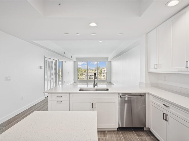 kitchen featuring white cabinets, stainless steel dishwasher, and kitchen peninsula