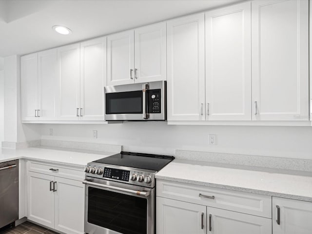 kitchen featuring white cabinets, light stone countertops, and stainless steel appliances