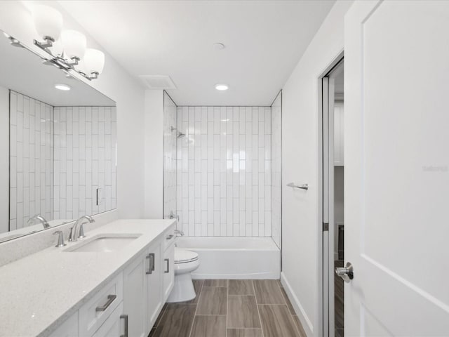 full bathroom with tiled shower / bath combo, toilet, vanity with extensive cabinet space, and tile flooring