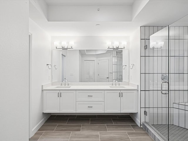 bathroom featuring an enclosed shower, double vanity, and tile floors