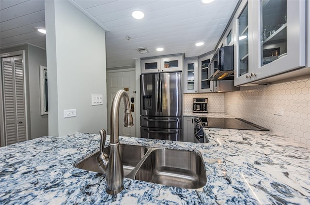 kitchen featuring stove, stainless steel fridge with ice dispenser, crown molding, backsplash, and light stone counters