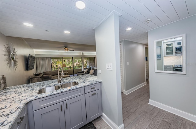 kitchen with light stone countertops, gray cabinetry, ceiling fan, sink, and stainless steel electric stove