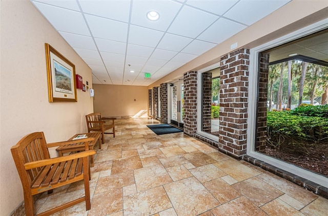 interior space with a paneled ceiling