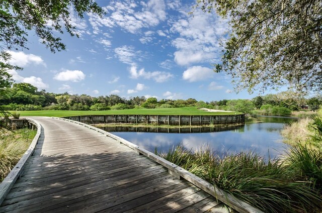 view of dock featuring a water view and a yard