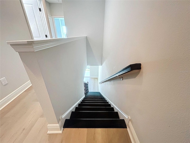 stairs featuring baseboards and wood finished floors