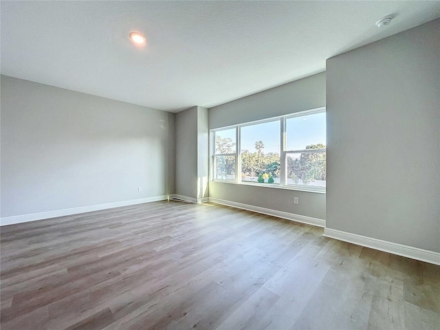 unfurnished room featuring baseboards and wood finished floors