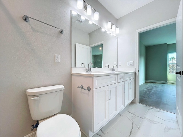 bathroom featuring vanity, toilet, baseboards, and marble finish floor