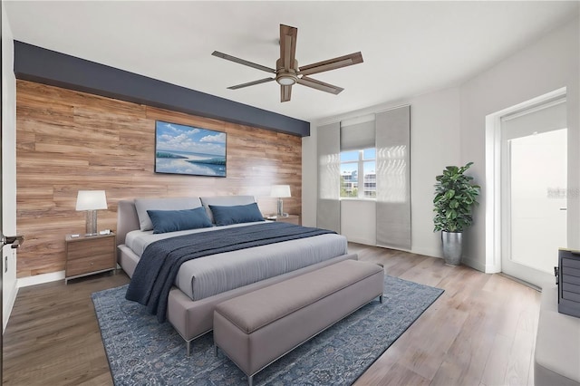 bedroom featuring wood-type flooring, ceiling fan, and wood walls