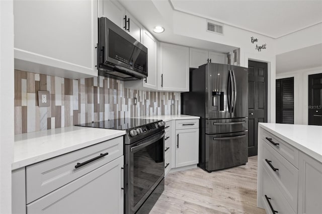 kitchen with white cabinetry, stainless steel refrigerator with ice dispenser, black electric range, decorative backsplash, and light wood-type flooring