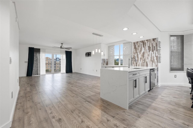 kitchen with sink, white cabinets, hanging light fixtures, ornamental molding, and light hardwood / wood-style flooring