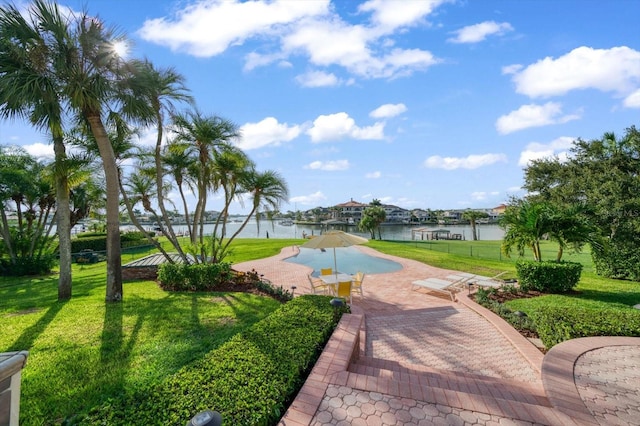 view of property's community featuring a patio, a lawn, and a water view