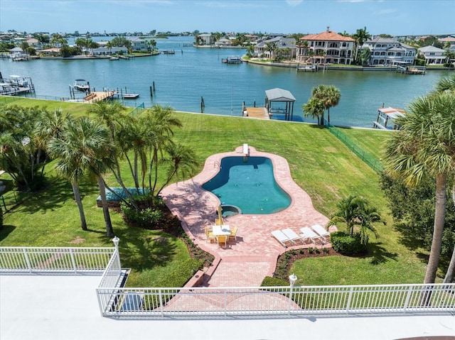 view of pool with a water view, a boat dock, and a lawn