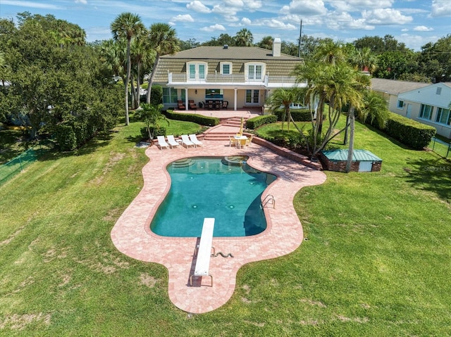 view of pool featuring a patio area, a diving board, and a yard