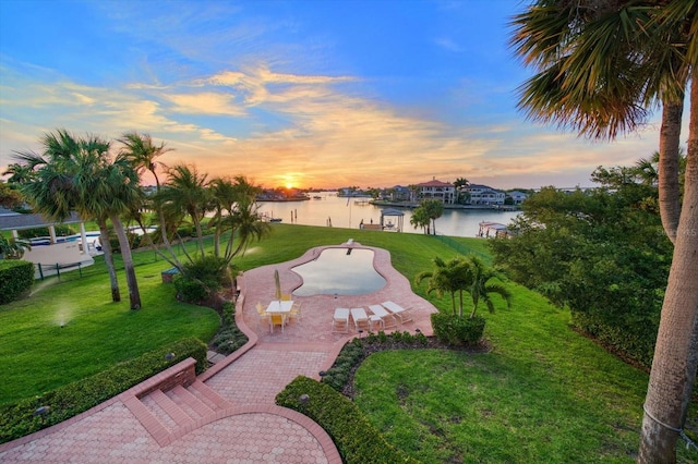 view of home's community featuring a water view, a patio area, and a lawn