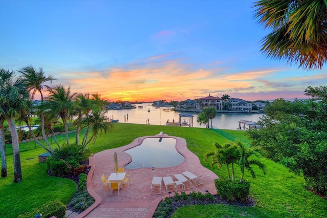 surrounding community with a patio, a yard, and a water view