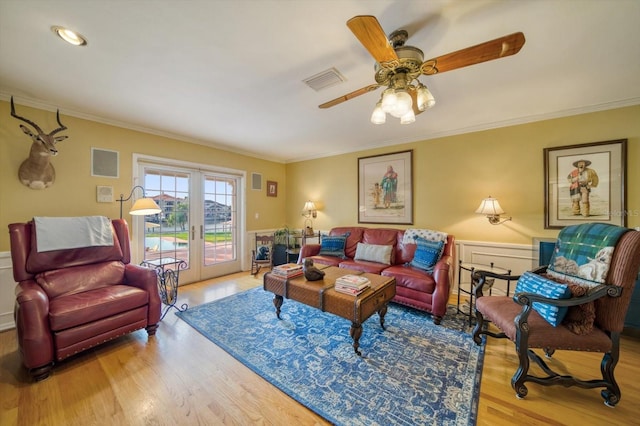 living room featuring wood-type flooring, ceiling fan, and crown molding