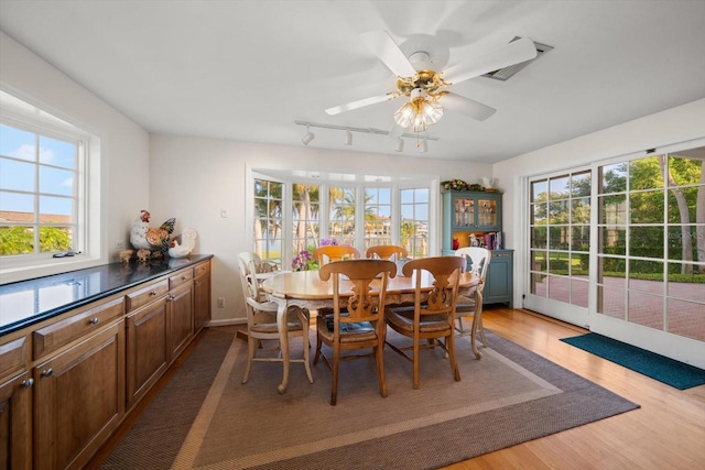 dining area with rail lighting, ceiling fan, and light wood-type flooring